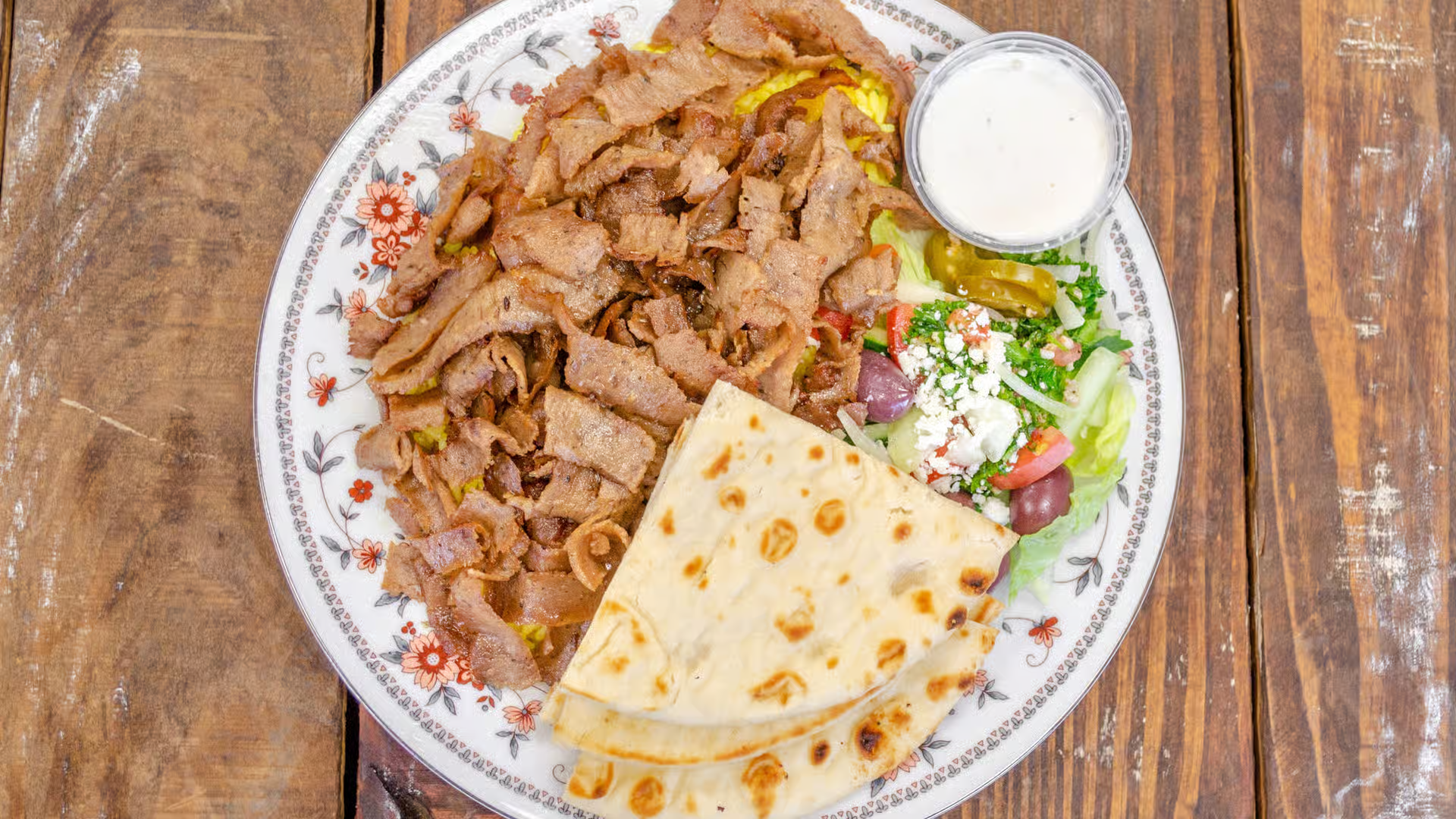 Chicken Platter - Grilled chicken served on top of rice, with your choice of lettuce, tomatoes, onions and cucumbers or tabbouleh salad, and pita bread.