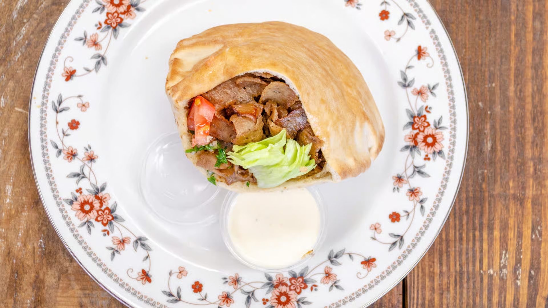 Gyro Sandwich - Sliced beef & lamb served with your choice of fresh lettuce, tomatoes, onions, cucumbers & dressing.